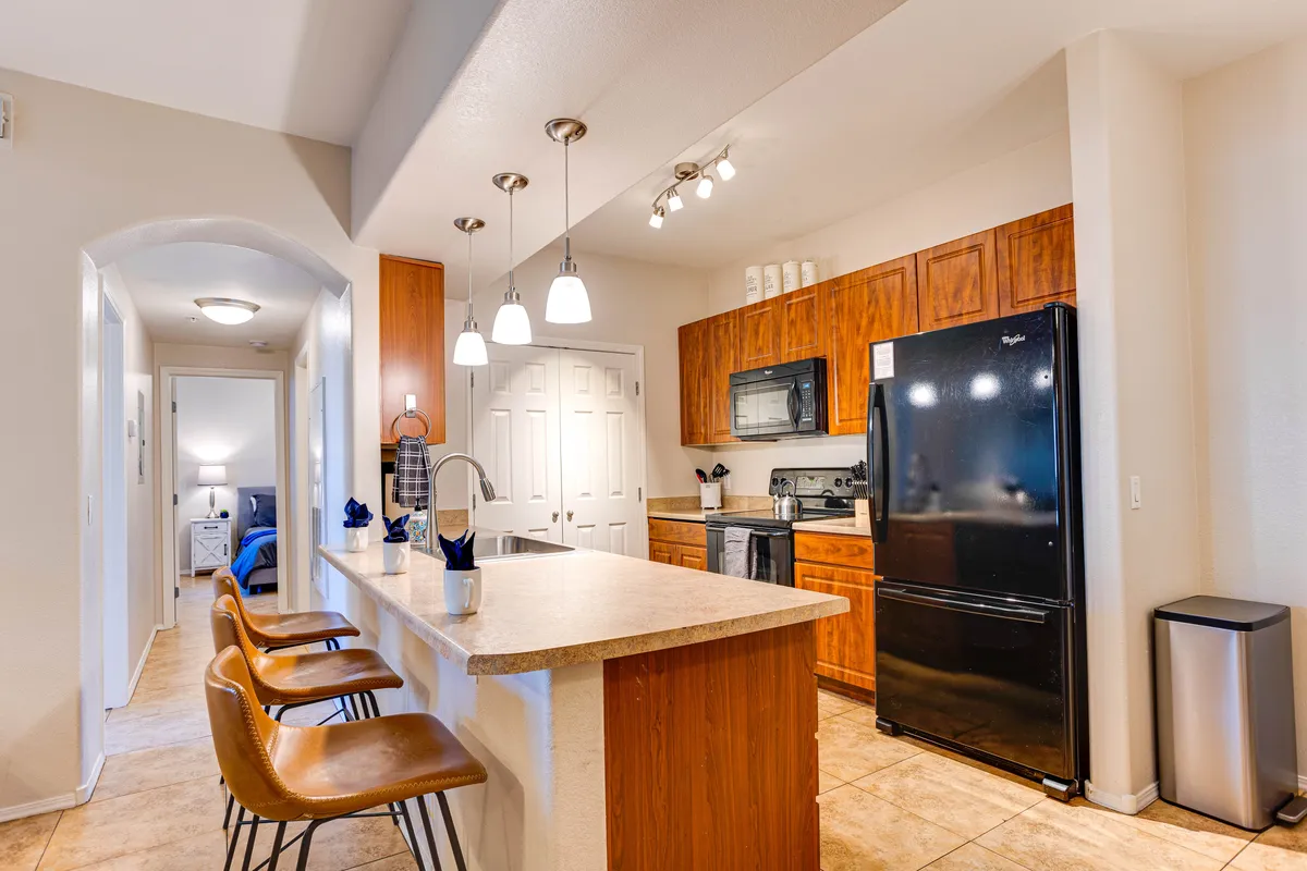 A modern kitchen with an island, bar stools, appliances, and generous cabinetry. The space is bright and functional, perfectly suited for meal prep, casual dining, and entertaining.